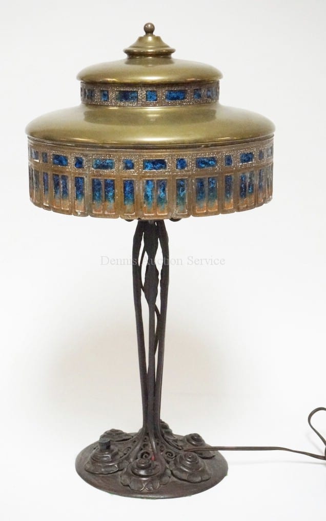 LOUIS C. TIFFANY FURNACES BRONZE LAMP SHADE WITH EDGAR BRANDT WROUGHT IRON BASE. SHADE SIGNED *LOUIS C. TIFFANY FURNACES INC 850* AND HAS ENAMELED WIRE MESH PANELS. BASE MARKED *MADE IN FRANCE* AND *E. BRANDT*. 20 1/4 INCHES TALL. 10 3/4 INCH DIA. sold by Dennis Auction Service, lot 1001 — auction record photograph