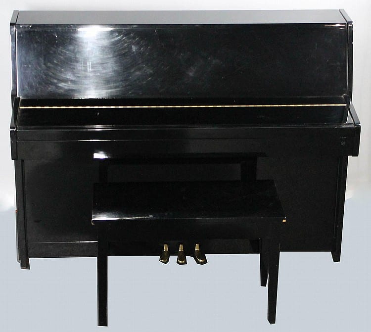 Black upright piano with open top and a small bench in front, photographed from the front.