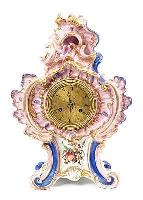 Ornate French-style mantel clock with a gilded brass clock face, decorative pink and gold scrollwork, and blue side accents.