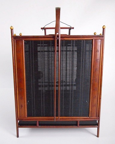 Antique wooden birdcage with a hinged front door and vertical metal bars, shown from the front against a light background.