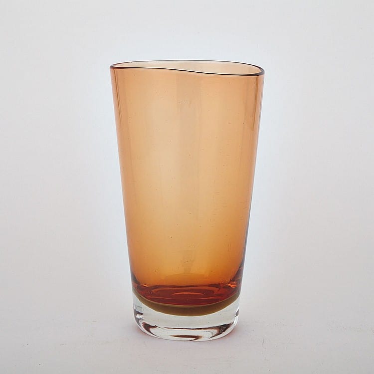 Amber glass vase with a clear rim and a darker amber base, photographed against a plain light background.