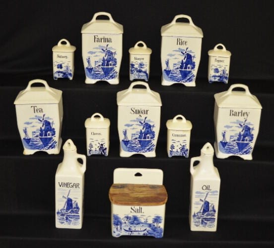 Thirteen Piece German Ceramic Canister Set with Delft Scenes: Rice, farina, barley, sugar, tea, salt box, oil and vinegar bottles, and six spice boxes, 10" Tallest sold by Tom Harris Auctions, lot 307 — auction record photograph