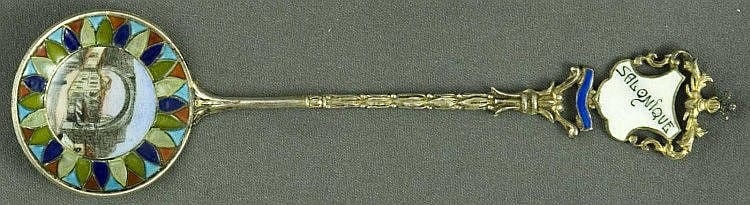 Small ornate souvenir spoon with a round enamelmed medallion bowl featuring a central figure and colorful geometric border; engraved handle end.