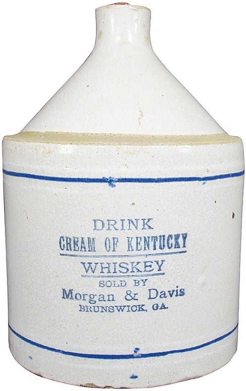 Front view of a white stoneware whiskey advertising jug with blue lettering reading "DRINK CREAM OF KENTUCKY WHISKEY."