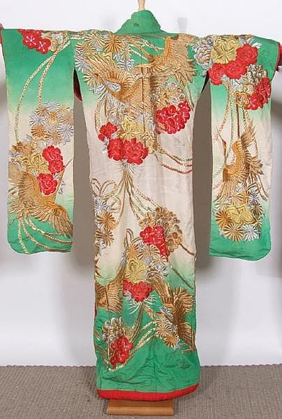 Front view of a green, gold, and red floral kimono robe with decorative patterns displayed on a stand.