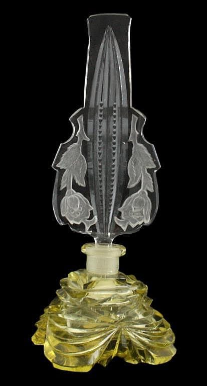 Vintage-style glass perfume bottle with a faceted clear stopper and an ornate cut-glass body in yellow-green tones.