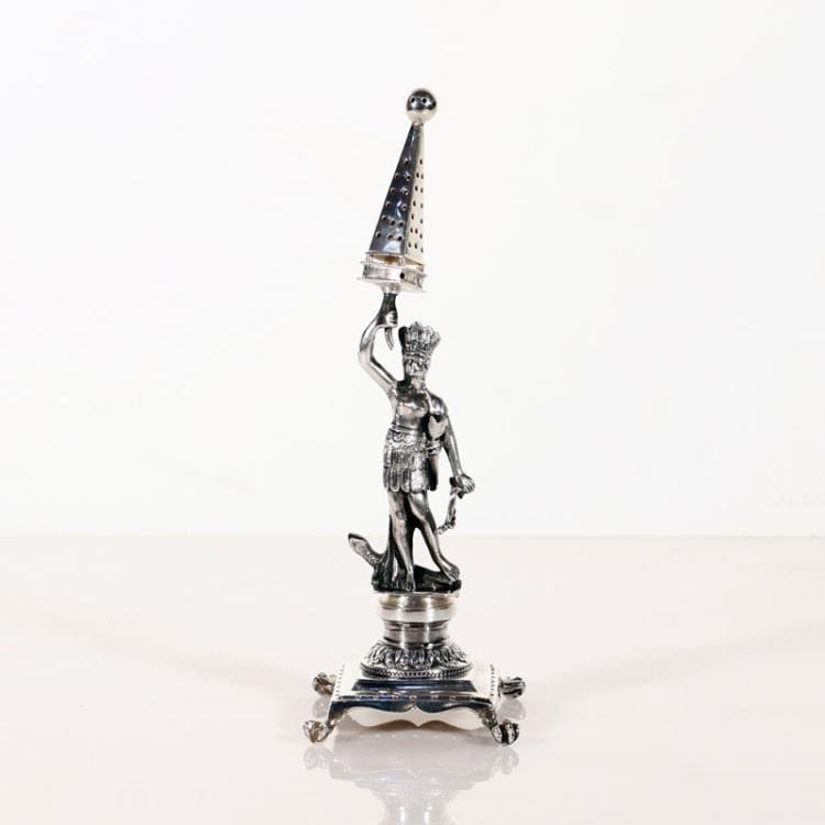 Silver-tone figure-shaped toothpick holder with a woman holding a stick and a funnel-like perforated top, on a base with four feet.