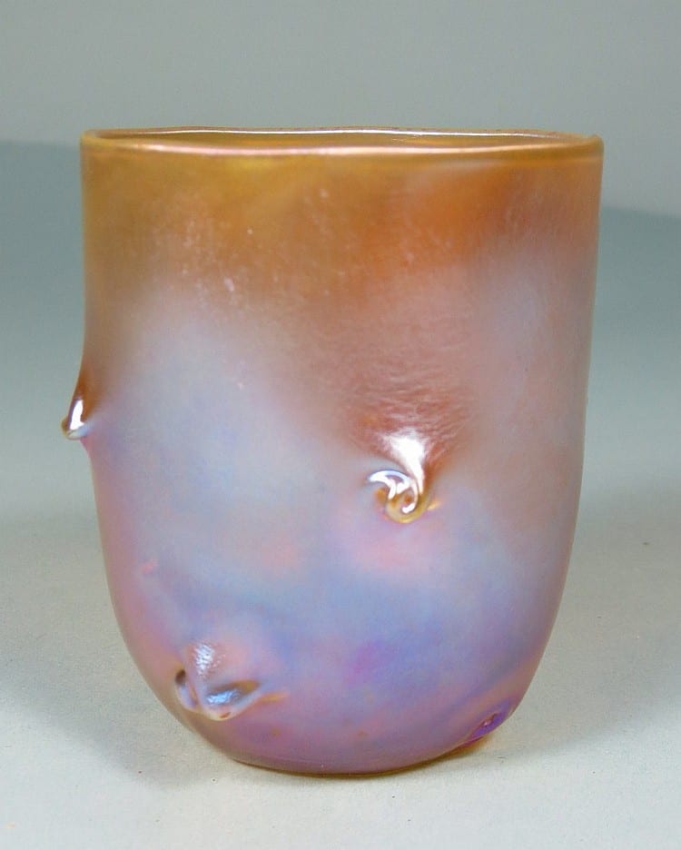 Colorful iridescent glass toothpick holder with an open top and decorative fish-like swirl accents.