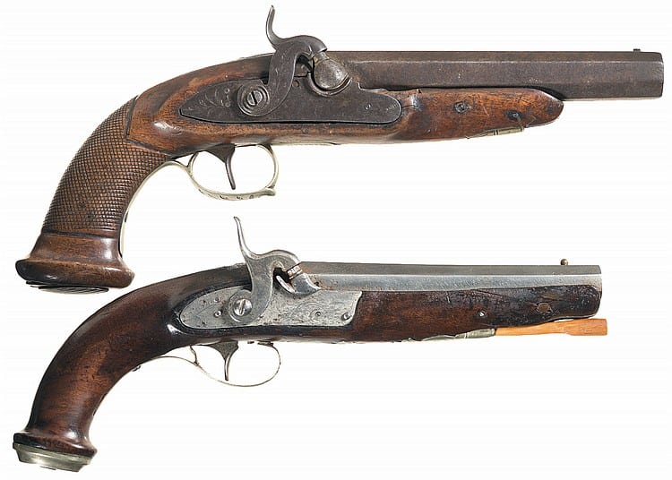 Two old percussion pistols shown side by side, with brown wooden grips and dark metal barrels and mechanisms.