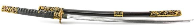 Long sword with a dark, decorated hilt and scabbard, shown horizontally with the blade extending to the right.