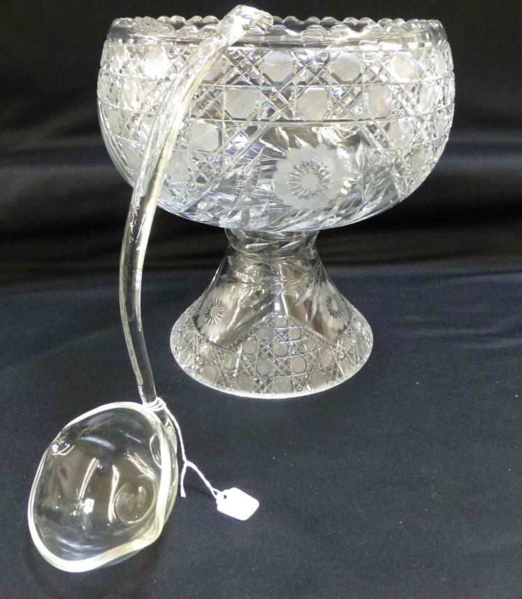 Clear cut-glass punch bowl on a pedestal with diamond pattern, starburst medallion, and a matching ladle.