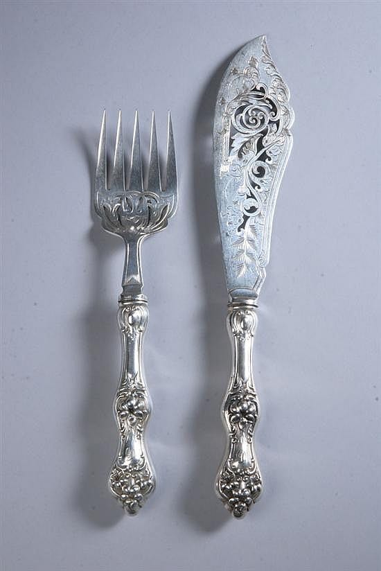 Two-piece fish serving set in silver tone: a fish knife with ornate handle and a matching fork with four tines.