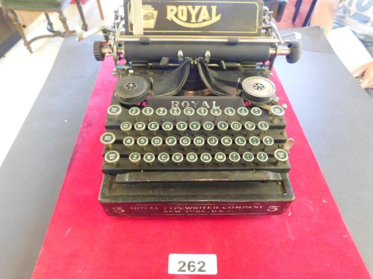 Vintage Royal typewriter on a red cloth, shown from the front with keys and ribbon cover visible.