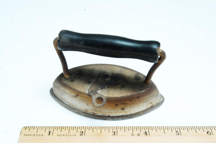Small vintage sad iron with a rounded soleplate and a dark handle frame, shown on a white background.