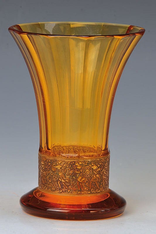 Amber glass vase with fluted vertical sides and an etched decorative band near the base, shown against a gray background.
