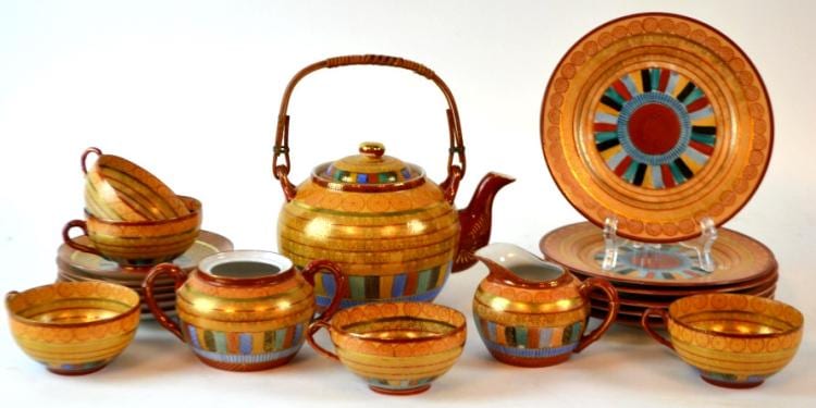 Japanese-style Kutani tea set with a lidded teapot, small cups and bowls, and a decorative plate with circular pattern, shown on a white background.