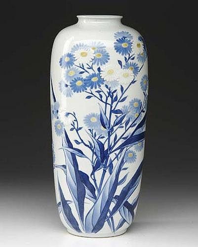 White porcelain vase with blue floral painting and stems, shown against a dark background.