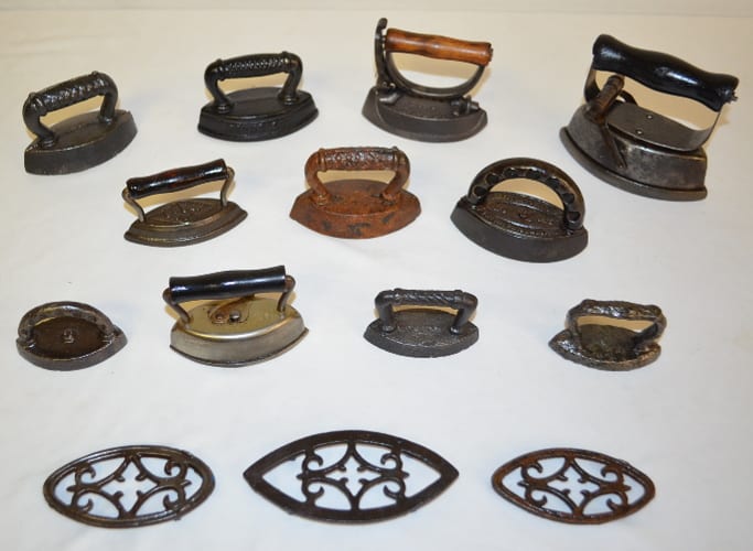 Eleven Antique Cast Iron or Steel Small Size Sad Irons, Eye Style: 1 advertising Round Oak Stoves and Ranges, 1 AsBestos, 1 Sensible No. 6, 1 Dover U.S.A, 1 Enterprise Mfg. No. 115, 6 assorted styles sold by Tom Harris Auctions, lot 341 — auction record photograph