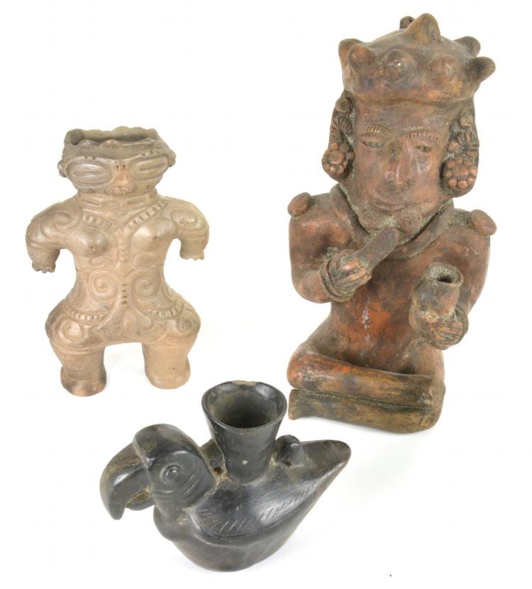 Two small modeled pottery figure vessels: a seated human-like figure on the left and a larger standing figure-like vessel with a dark opening on the right, plus