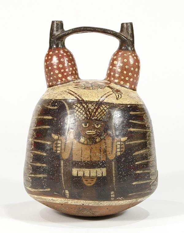 Ceramic stirrup vessel with two side handles and painted figures and geometric bands in brown, black, and cream.