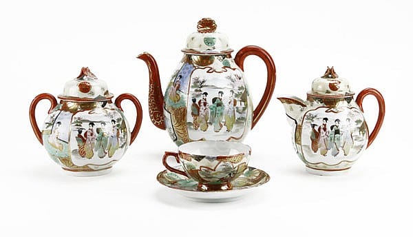 Japanese Kutani-style tea set with three lidded teapots and a teacup, decorated with colorful figures on a white background.