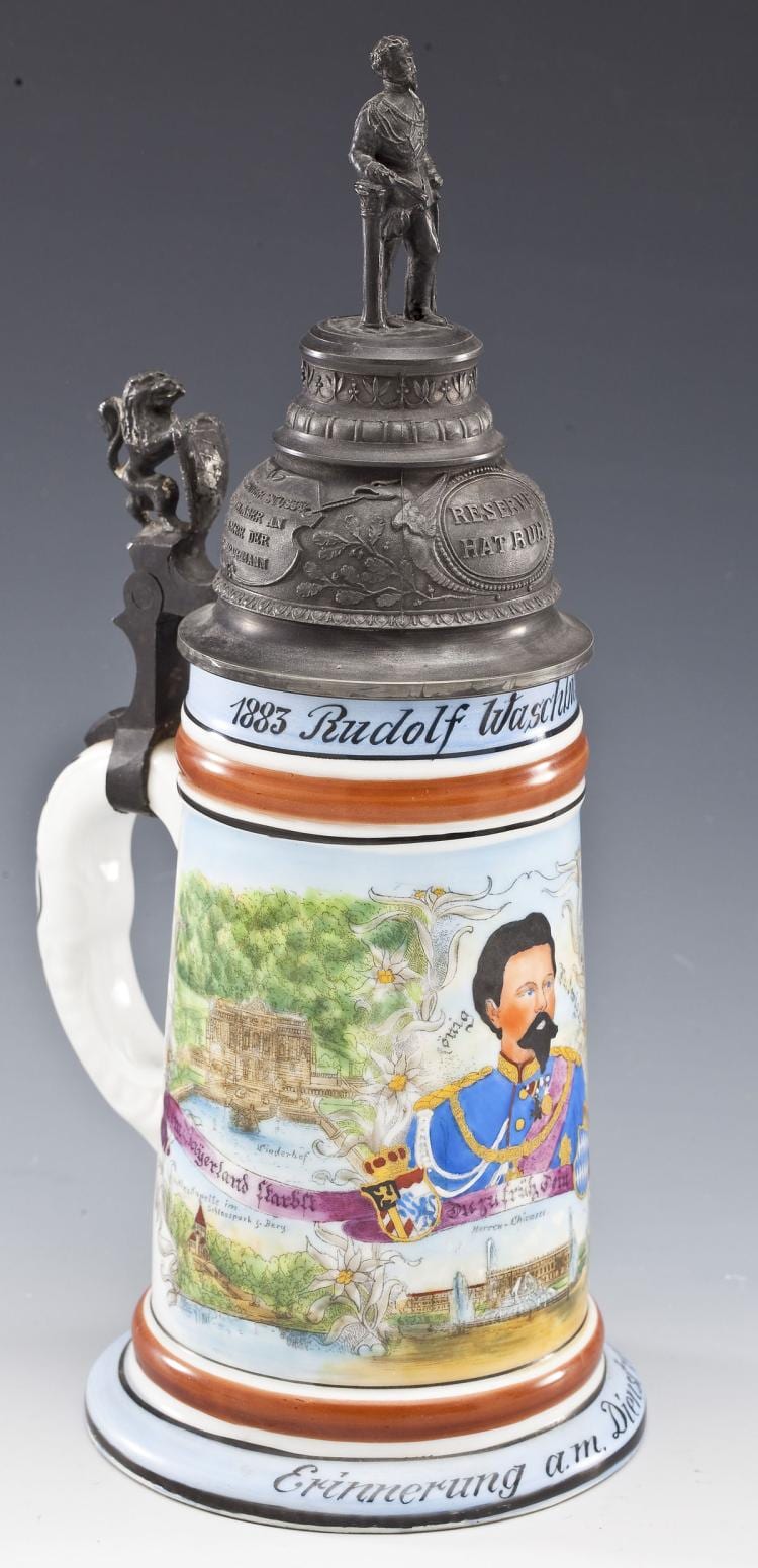 Porcelain beer stein with a metal lid and handle, decorated with a painted portrait, landscape scene, and regimental-style bands.