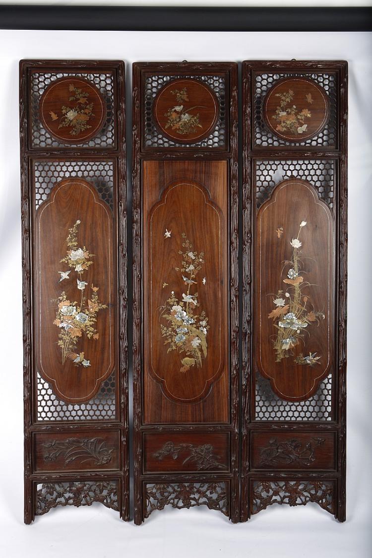 A JAPANESE THREE PANEL WOODEN SCREEN. Meiji Period. Each panel with a central compartment inlaid with bronze, brass, silver and mother of pearl, to depict animals and birds among flowers, below a circular panel each set within a reticulated ground, within borders carved as gnarled tree trunks, above a wooden panel with incised flowers and an open carved apron depicting squirrels and grapes, 133 x 30cm. (3) sold by Chiswick Auctions, lot 358 — auction record photograph