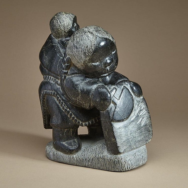 Johnny Inukpuk comparable auction result: johnny inukpuk r c a inukjuak port harrison woman scraping a skin with child in her amaut stone 12 ins x 10 ins x 6 ins 30 5 cms x 25 4 cms x 15 2 cms
