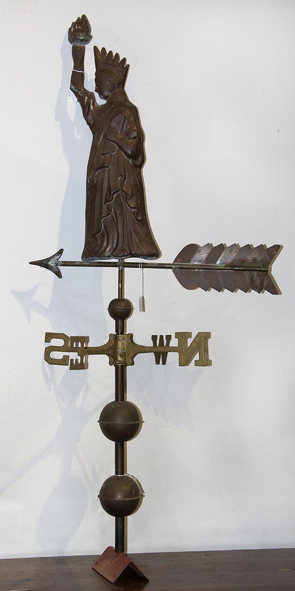 Bronze or copper weathervane with an angel holding a sword and standing atop a long arrow finial weather vane.