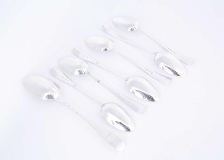 Group of four antique-style silver table forks on a white background.