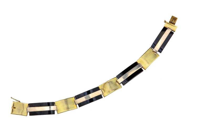 An Art Moderne onyx bracelet, circa 1935 Of bi-coloured design, the rectangular onyx plaques set between engraved spacers, maker's mark SF, Austrian assay mark, length 19.0cm In 1929 a group of disillusioned decorative artists, including jewellers and architects, founded the Union des artistes modernes in France. The group's ethos was a reaction against the established style of the time. The copious excess of the 1920s led to the development of a style focused more on artistic rather than intrinsic value. The Union proclaimed, "We must rise up against everything that looks rich, against whatever is well made, and against anything inherited from grandmother...impose will where habit is not invoked...overcome the habit of the eyes." Designs frequently incorporated less expensive metals such as lower carat golds, silver, brass or even chrome and the use of semi-precious over precious stones was preferred. The style became much flatter and starker with a theme of industry and mechanism being apparent. sold by Chiswick Auctions, lot 94 — auction record photograph