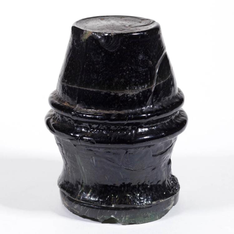 Dark green glass telegraph insulator with a rounded top and ridged banded base, photographed against a white background.