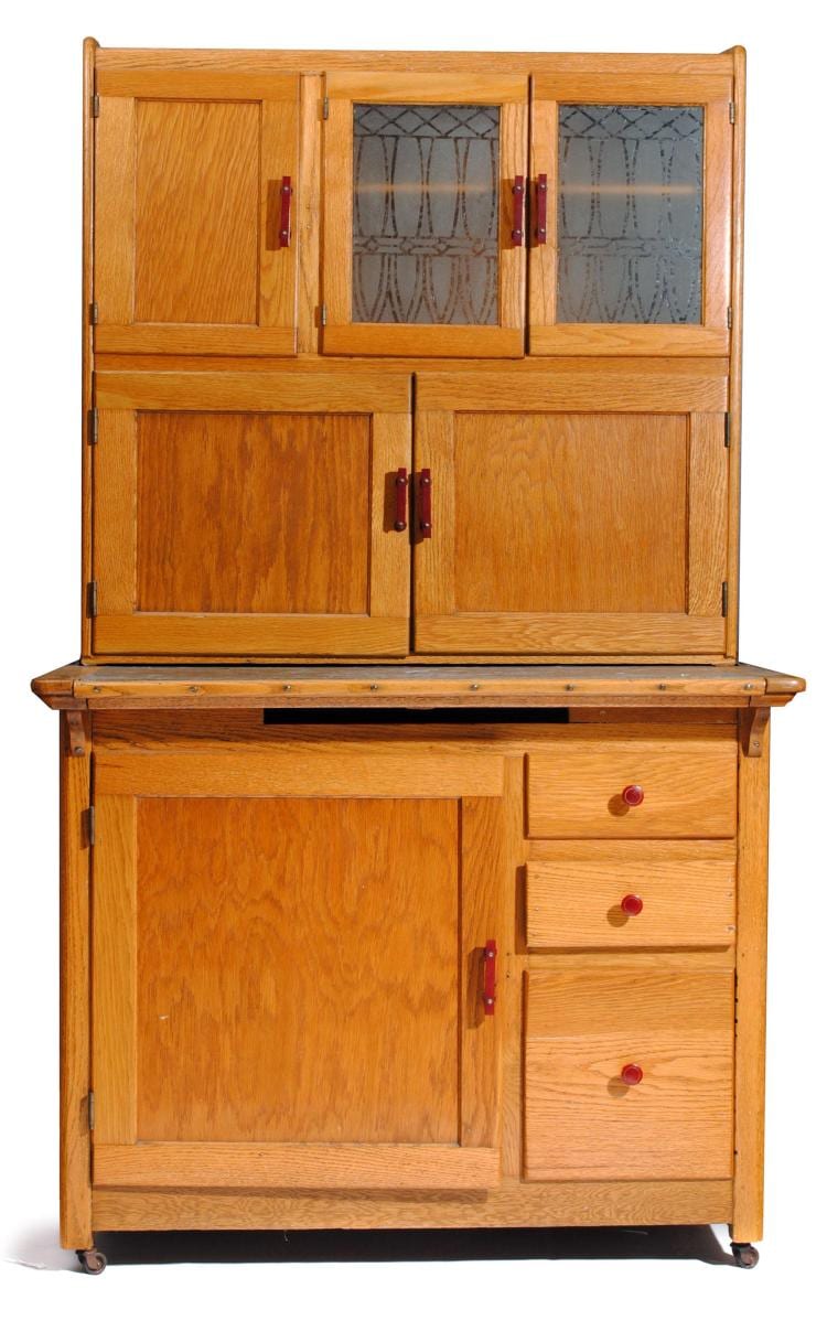 Wooden Hoosier-style cabinet with upper doors, glass panels, and lower drawers and cabinet door.