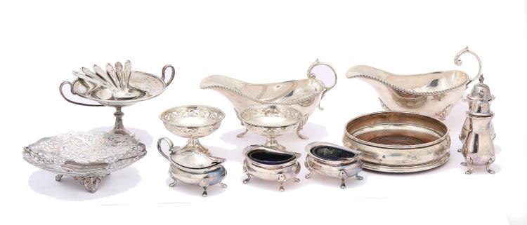 A mixed group of antique sterling silver items, including a pair of silver-mounted glass decanters, Birmingham 1963, by Barker Brothers Silver Ltd With plain silver collars, height 30 cm/11.8 inches, a pair of sauceboats, Birmingham 1961, with gadrooned rim and flying scroll handles length 17.5 cm/6.8 inches, a silver wine coaster, London 1995, with turned wood base, a set of six coffee spoons, Sheffield 1960, by E Viners, a five-piece condiment set, Birmingham 1963, comprising: two salts, two peperettes and a mustard pot, matched with two condiment spoons, a small pair of pierced bonbon dishes, two further bonbon dishes and a pair of sugar tongs. (Qty) Weight of weighable silver – 1229 grams/ 39.51 ozt sold by Chiswick Auctions, lot 150A — auction record photograph