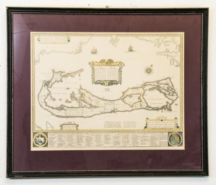 Framed vintage-style map print showing islands and coastlines, with small decorative cartographic text and two circular compass-like insets at the bottom.