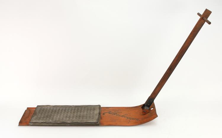 Wooden skee boggan sled with a curved runner, handle bar, and gray fabric footrest.
