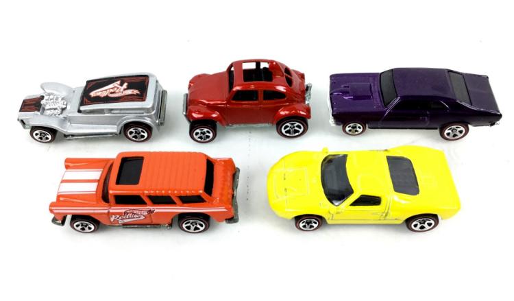 Five colorful die-cast Hot Wheels-style toy cars, including red, purple, silver, orange, and yellow models, photographed on a white background.