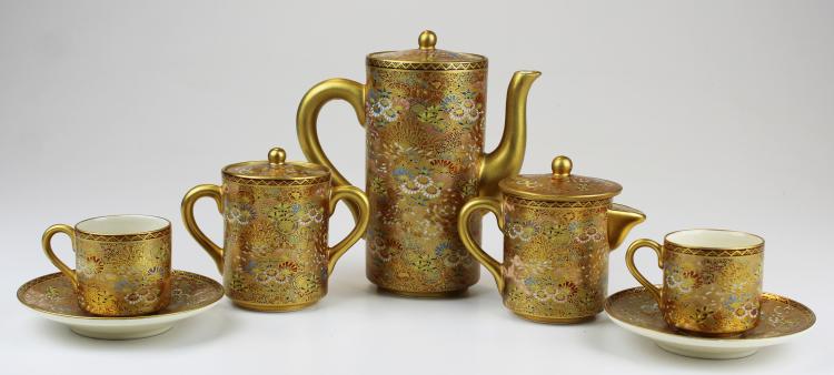 Five-piece Japanese-style Kutani tea set with gold-colored handles and floral pattern, including two teacups on saucers and a teapot plus creamer and sugar.