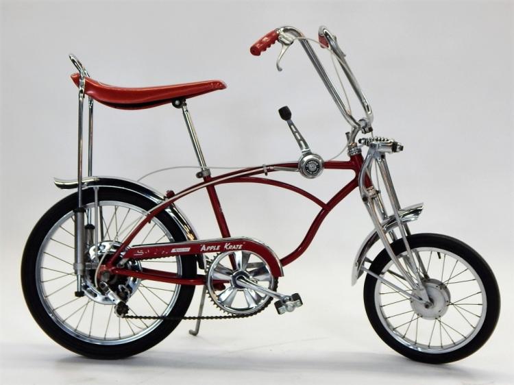 Red and burgundy vintage Schwinn Apple Krate bicycle with chrome fork, handlebars, and front disc brake, photographed in profile against a light background.