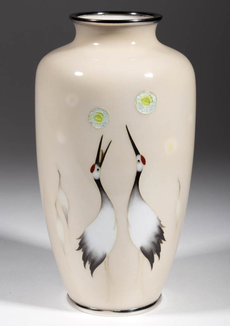 White ceramic vase with dark rim, decorated with two cranes in flight and small circular accents near the top.