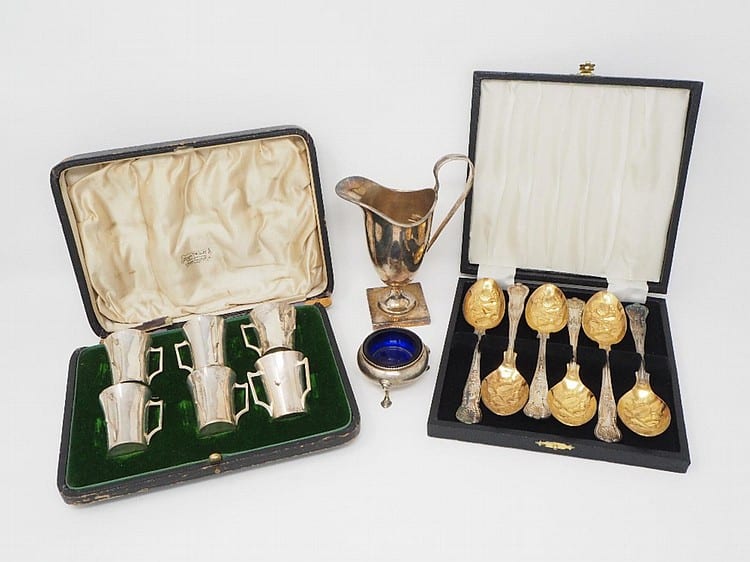 A SET OF SIX GEORGE V SILVER LIQUEUR TOTS, MAPPIN & WEBB LTD., BIRMINGHAM, 1914of tyg beaker form, in original fitted case, 4.5cm high; together with a Victorian silver salt cellar, three footed cauldron form, with blue glass liner, Charles Stuart sold by Matthew Barton Ltd, lot 608 — auction record photograph