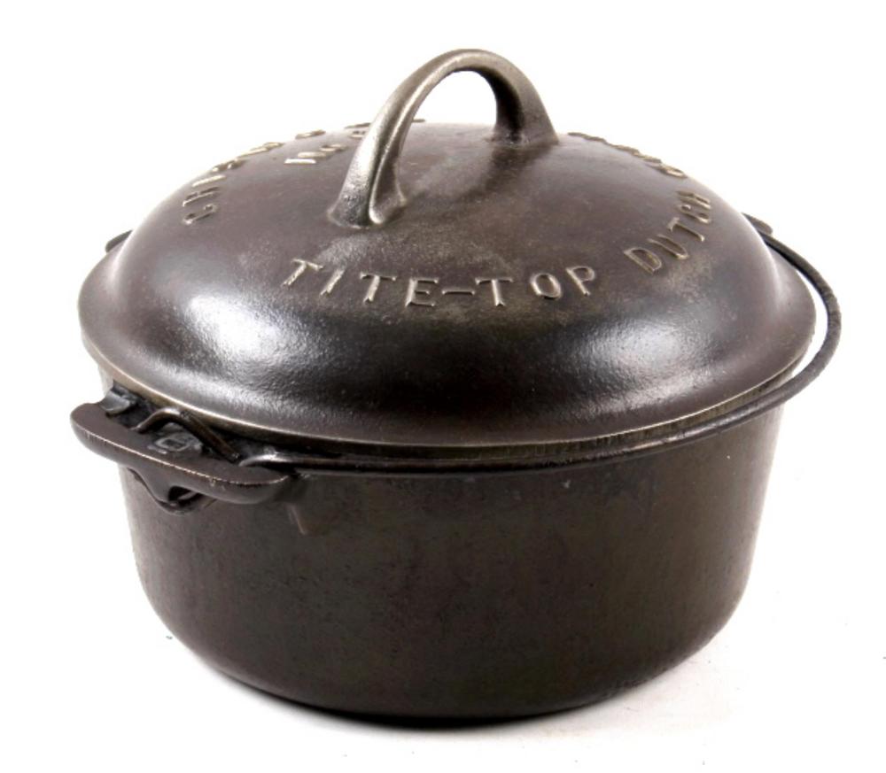 Dark cast iron tite-top Dutch oven with arched handle and lid labeled “TITE-TOP”.