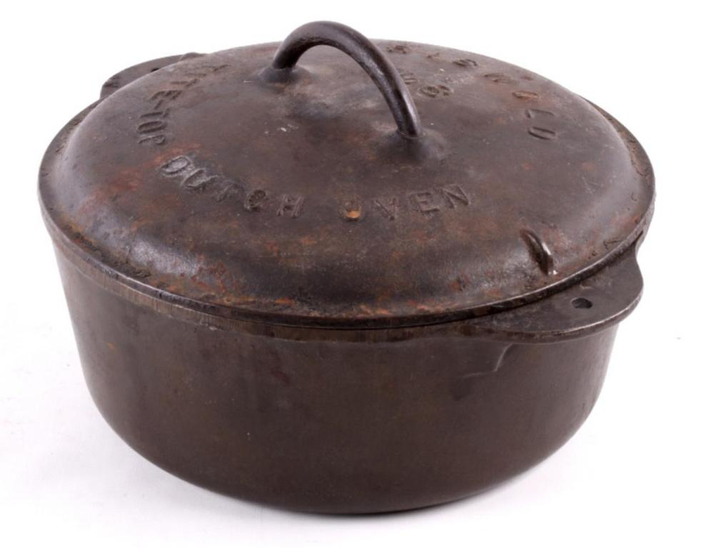 Brown cast iron dutch oven with a domed lid and arched handle on top, shown on a white background.