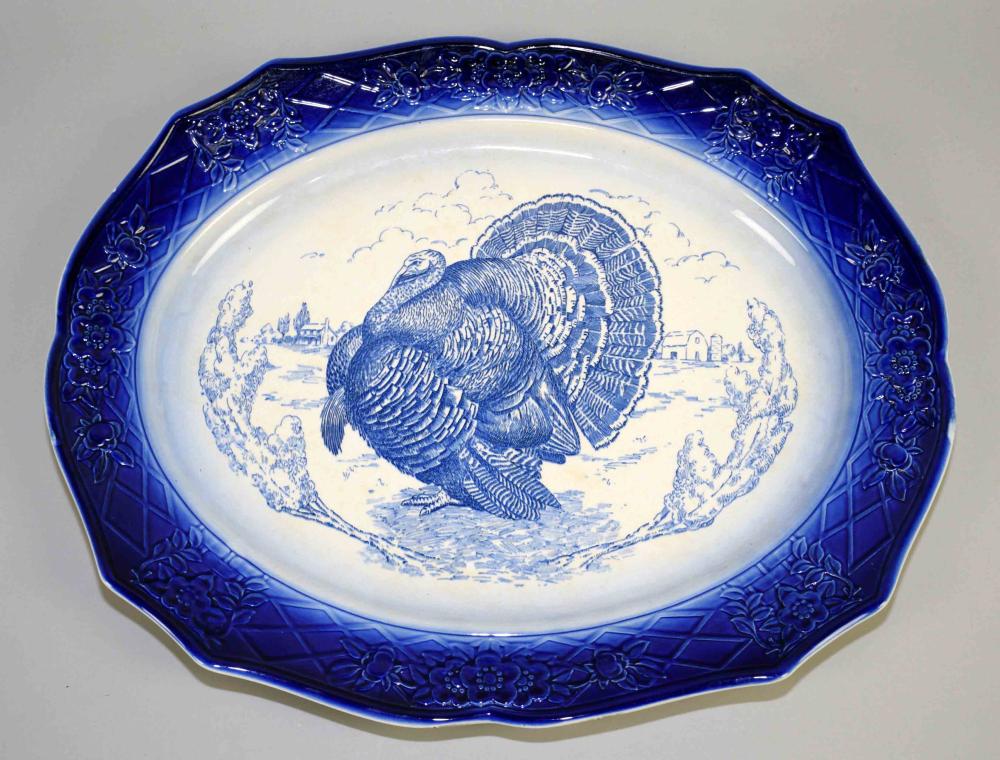 Blue and white decorative ceramic turkey platter with octagonal rim and floral relief border, featuring a turkey in transfer-style print.