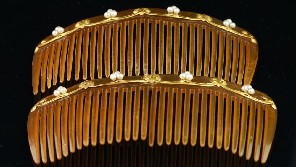 F. Gold comparable auction result: two pressed horn hair combs with gold and pearl detail a f