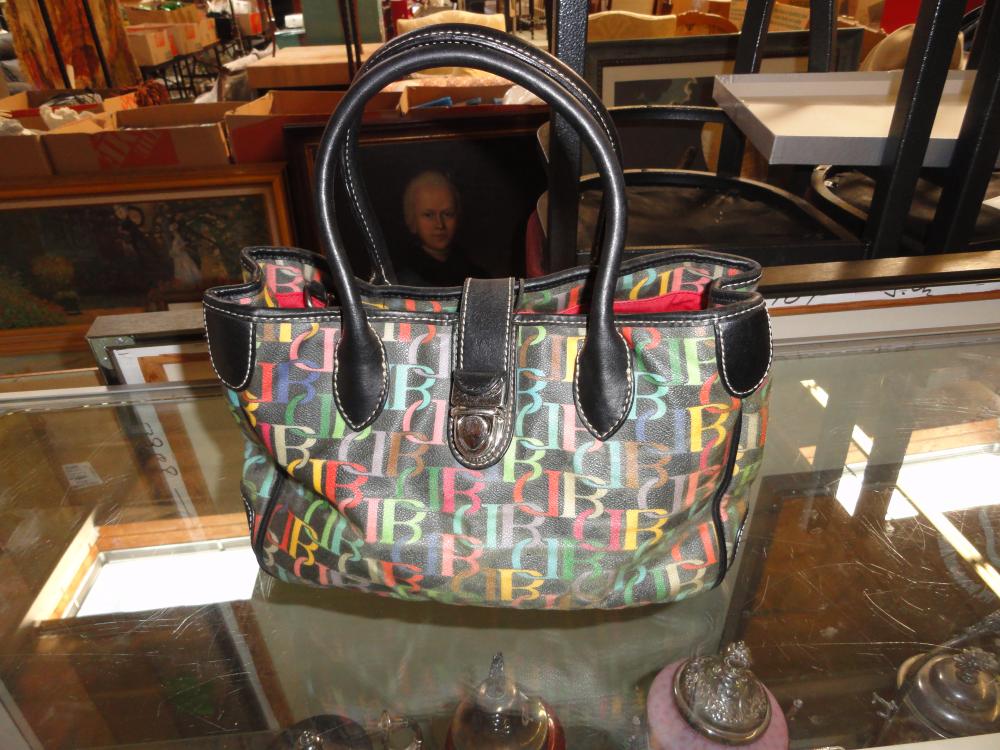Black small handbag with colorful multicolor patterned body, rounded top handles, and a front clasp.