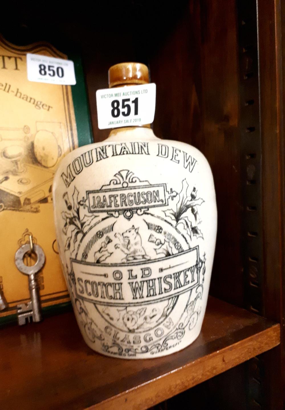 White advertising whiskey jug with blue printed label reading “J. A. Ferguson” and “OLD SOUTH BREWING WHISKEY,” with a gold-colored cap.