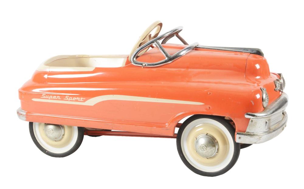 Orange pedal car toy with white side stripe, chrome steering wheel, and cream wheels on a light background.
