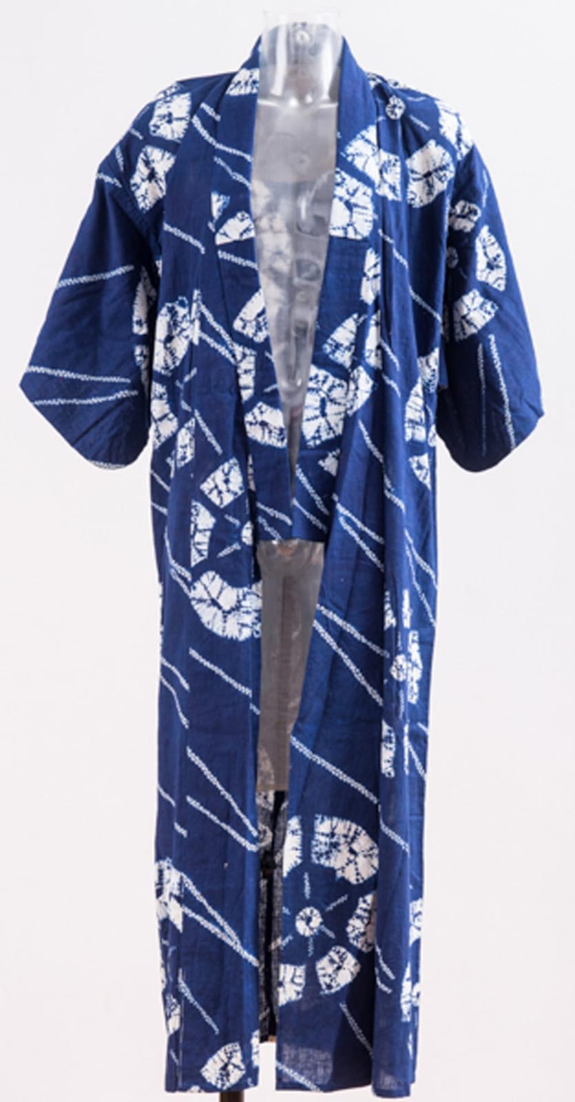 Front view of a blue kimono robe with wide sleeves and white abstract patterned motifs.