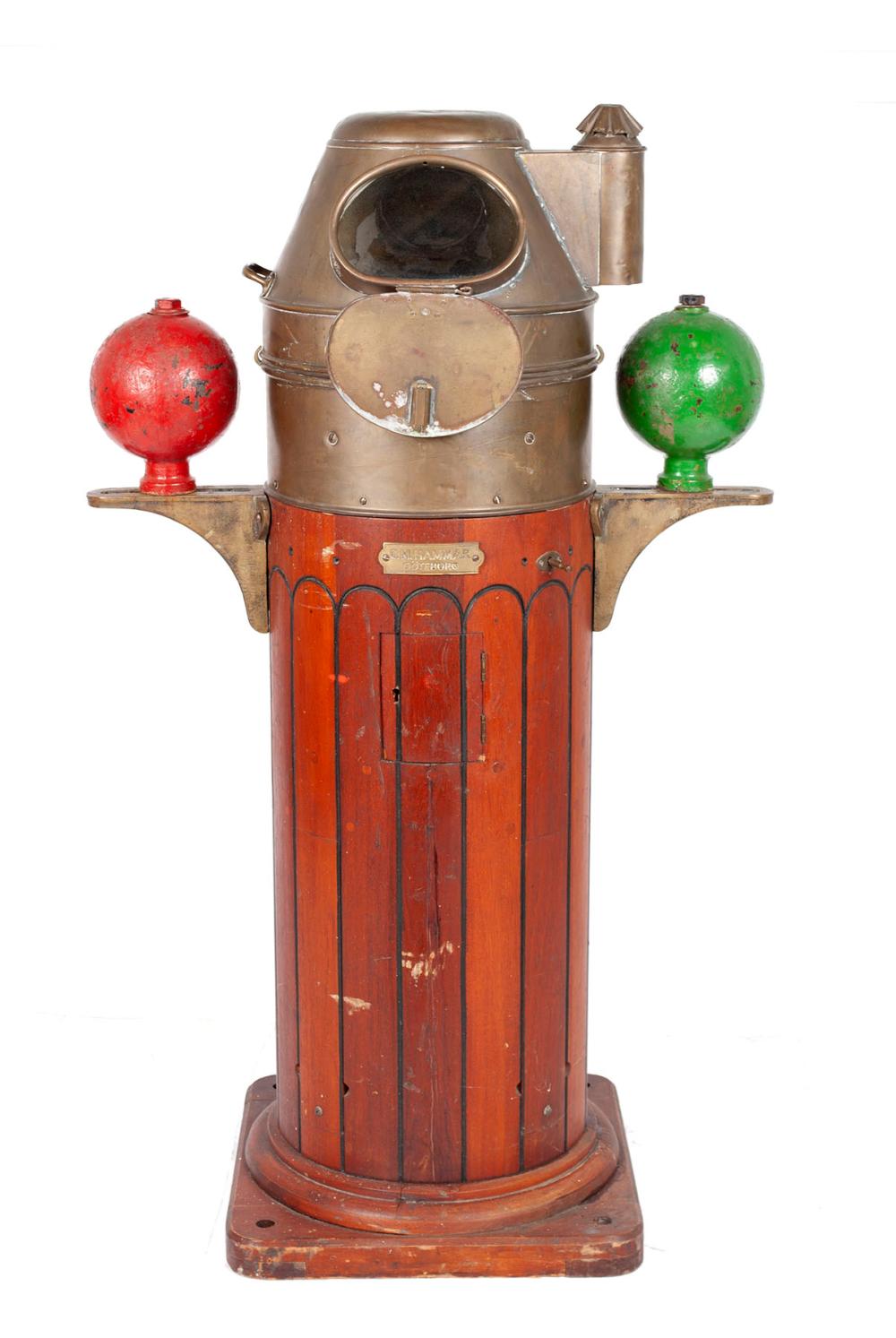 Brass and painted wooden compass binnacle with glass window on top and two colored globe-like finials (red and green).